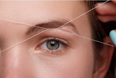 Professional eyebrow threading and shaping treatment